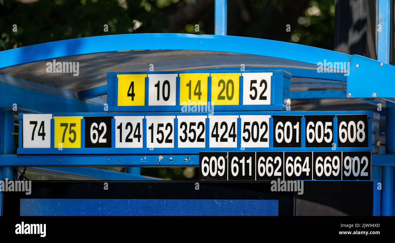 Bus or tram stop lots of different lines, connections, line numbers, number plates detail, closeup, transport information. Efficient city transportati Stock Photo