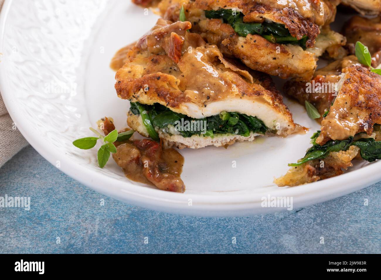 Spinach stuffed chicken on a serving platter Stock Photo