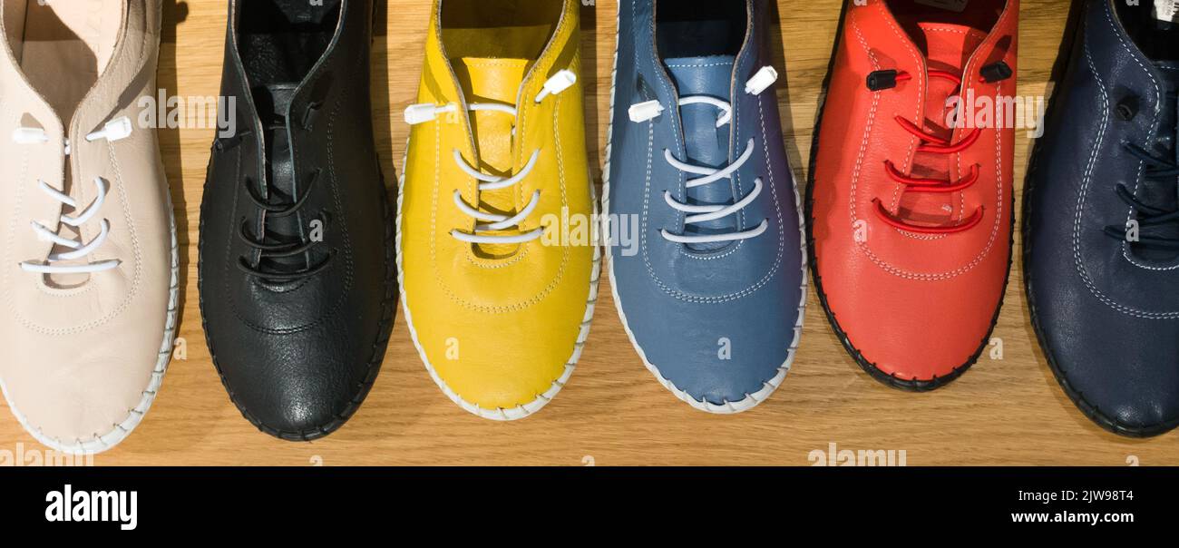 Photo of colorful leather shoes in shop. Variety of the colorful shoes Stock Photo