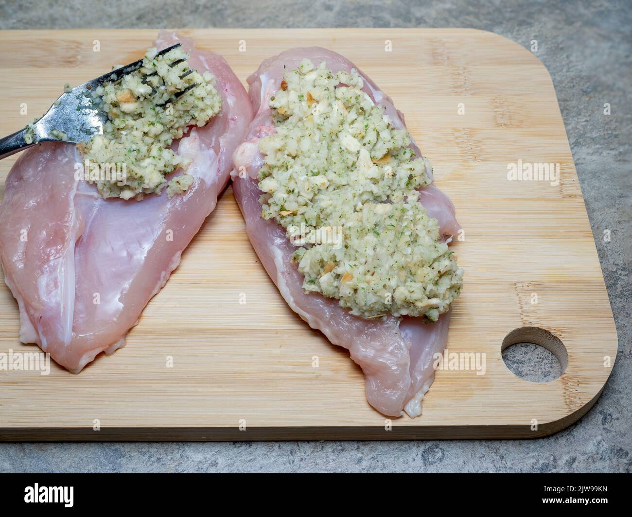 chicken breasts stuffed with sage and onion on a bamboo wooden board Stock Photo