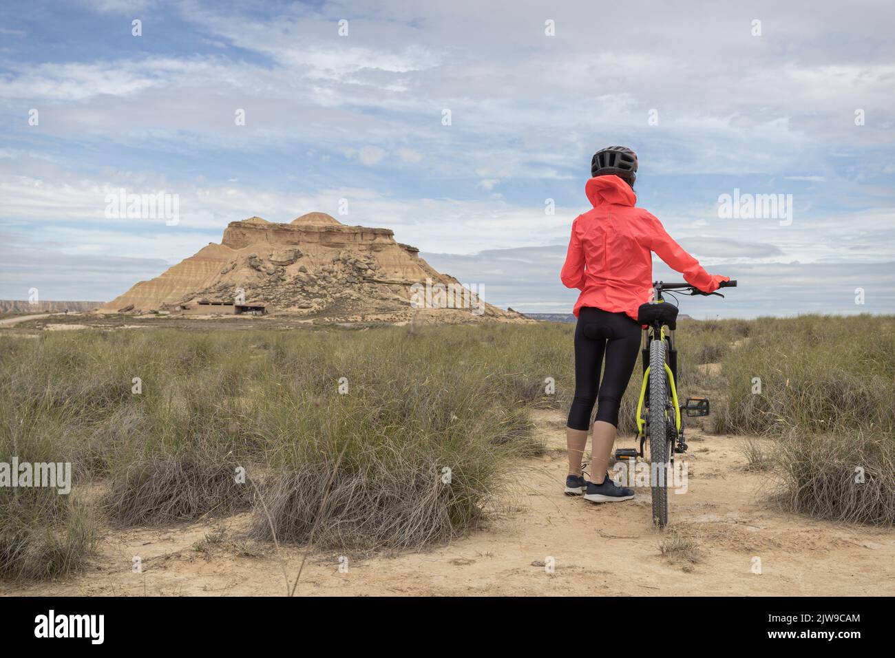 Young woman mountain bike cyclist in Badlans of Navarre (Bardenas Reales de Navarra) dessert in the middle of Spain. Stock Photo