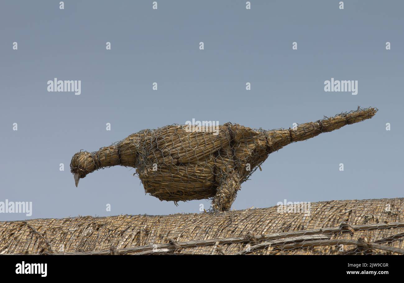 Pheasant shape made of straw as adornment on a thatched roof. Stock Photo