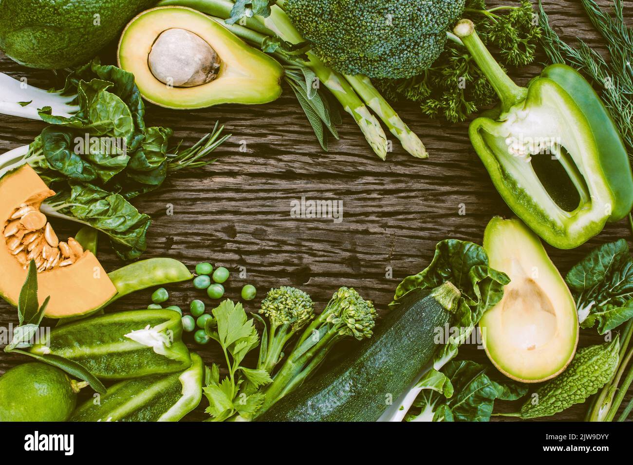 A top view of green vegetables and greens on the wooden table Stock ...