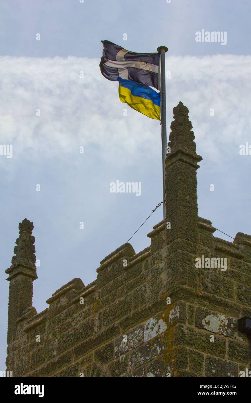 Cornish Saint Piran flag and Ukrainian flag flown in solidarity above a Cornish church. Stock Photo