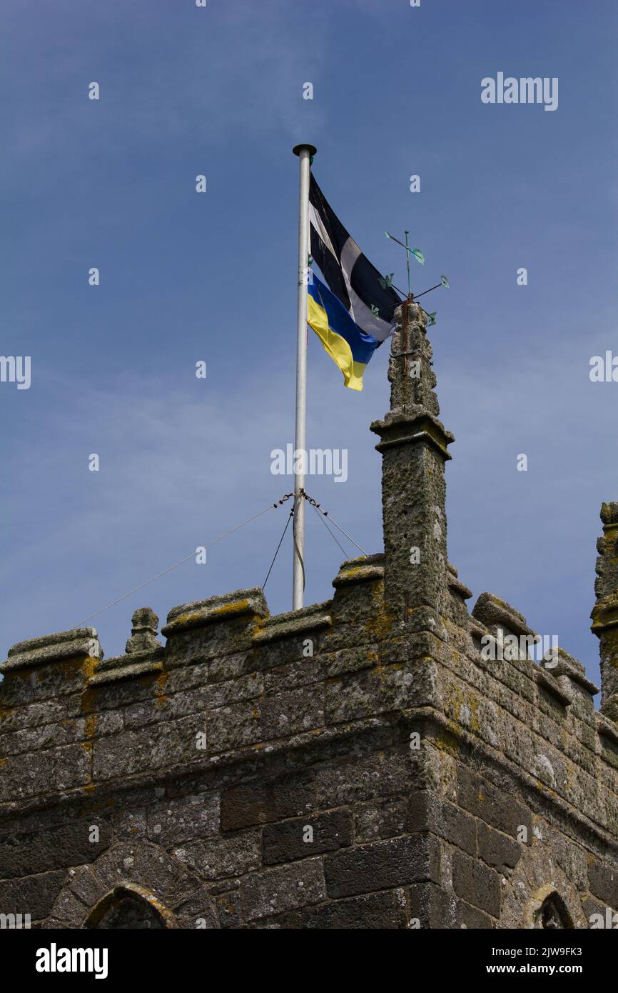 Cornish Saint Piran flag and Ukrainian flag flown in solidarity above a Cornish church. Stock Photo