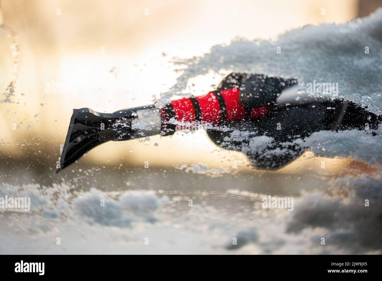 Close up of hand holding a snow scraper and removing ice from ...