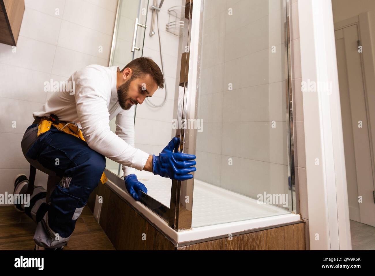 Plumber installing a shower cabin in bathroom Stock Photo Alamy