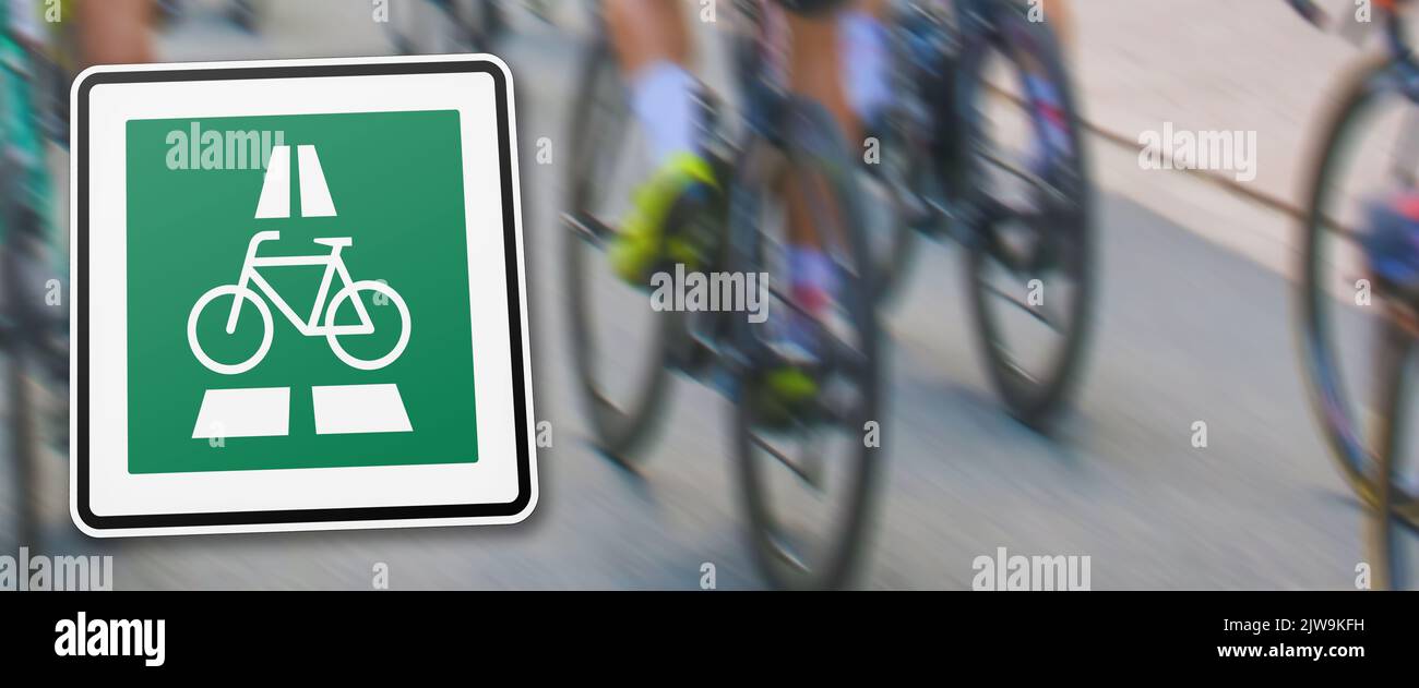 new german traffic sign indicating prioritized bicycle highway in front of a blurred background with different bicycles on a road Stock Photo