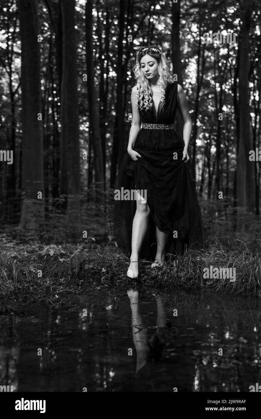 A grayscale of Pretty blonde female in a dress walking in the forest Stock Photo - Alamy A grayscale of Pretty blonde female in a dress walking in the forest Stock Photo - Alamy