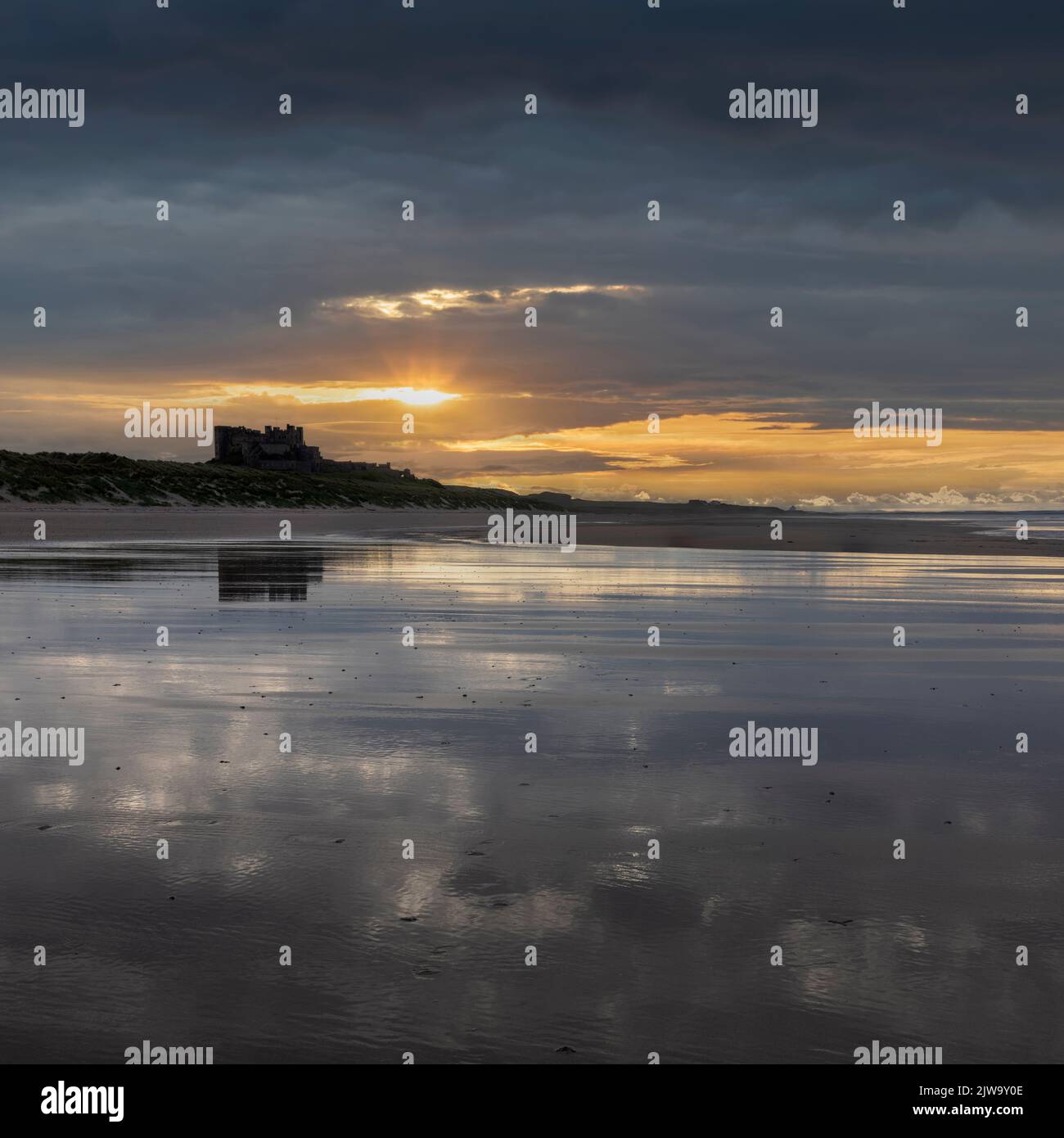 Bamburgh Castle from the beach to the south at sunset with no people Stock Photo