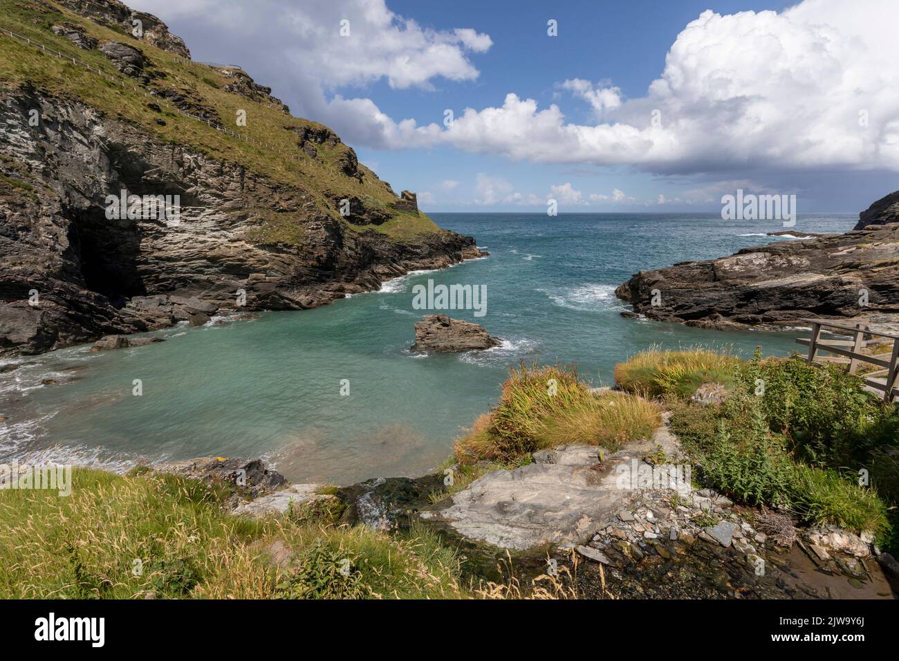 tintagel bay cornwall below the castle with blue sky and clouds Stock Photo