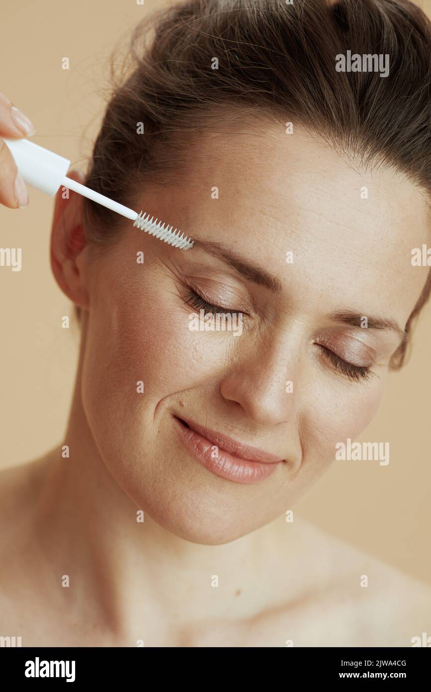 modern woman with brow brush on beige background. Stock Photo