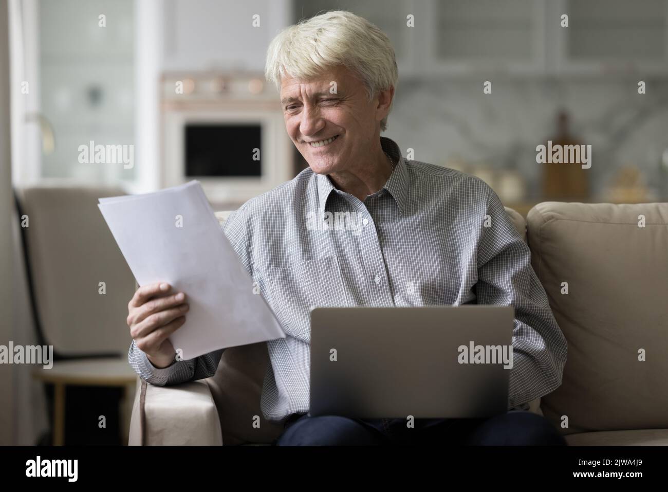 Happy mature grey haired man working from home Stock Photo