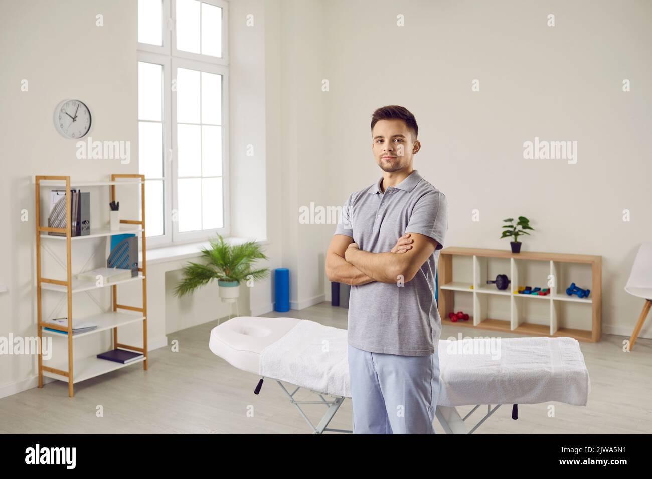 Male physiotherapist in uniform pose in clinic Stock Photo