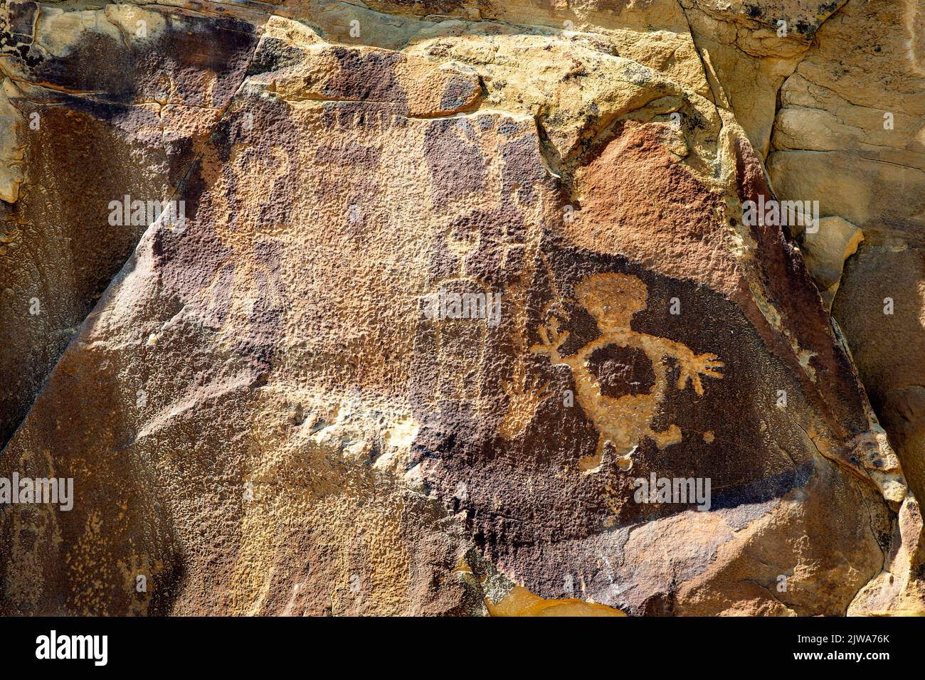 Petroglyphs rock art in Legend Rock State Archaeological Site, Wyoming - Several outlined and en toto pecked anthropomorphs are visible. The large fig Stock Photo