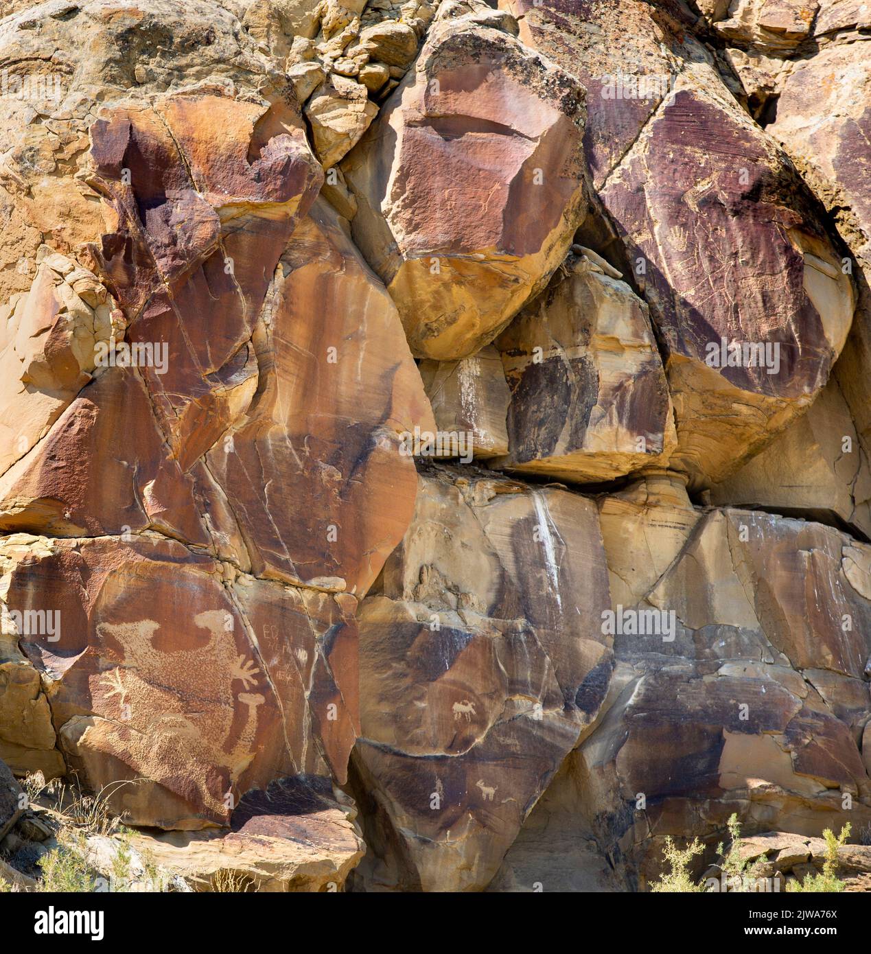Petroglyphs rock art in Legend Rock State Archaeological Site, Wyoming - Carved sandstone panels with anthropomorphic and zoomorphic animal figures cr Stock Photo