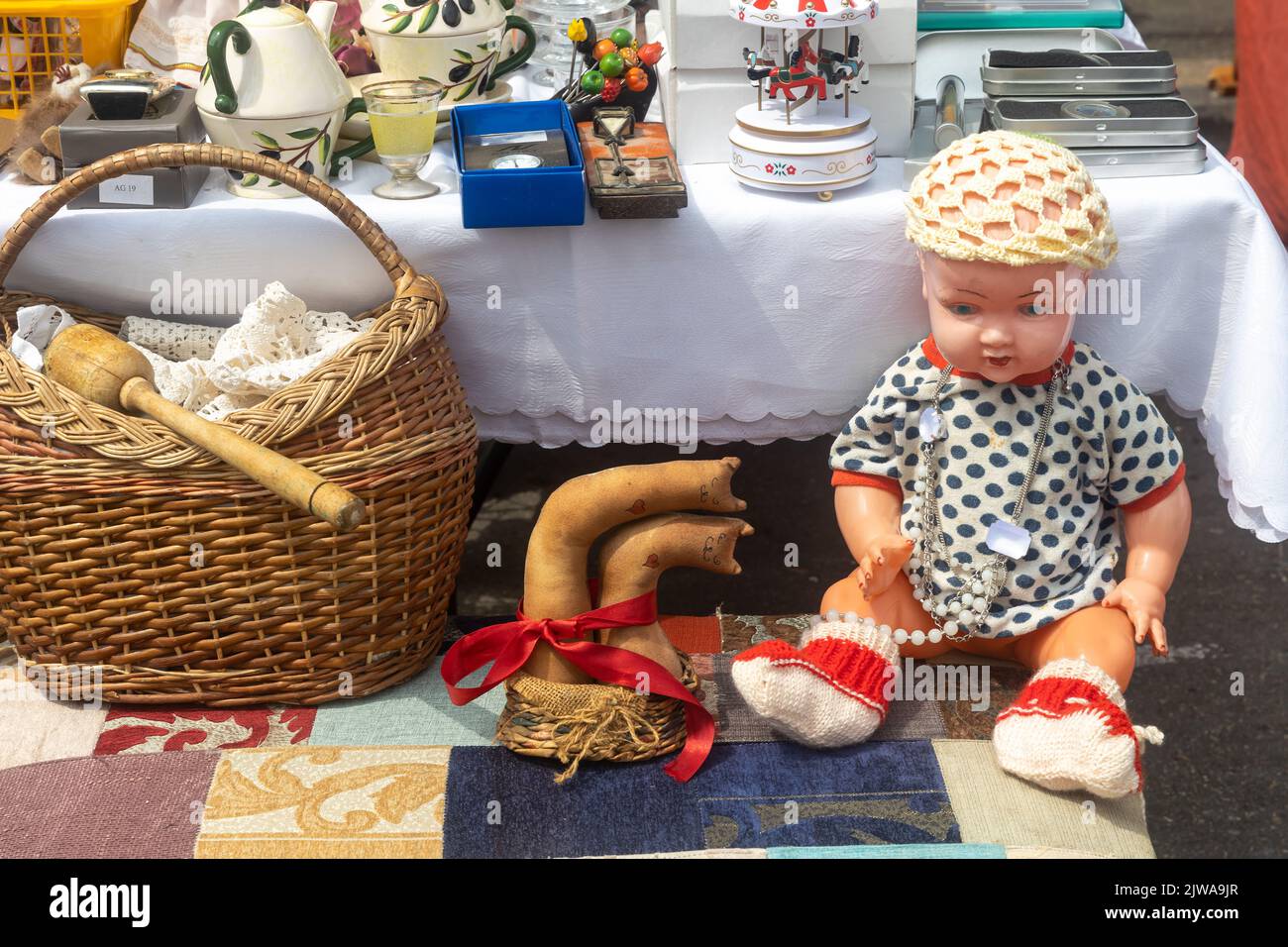 Haifa, Israel - September 02, 2022, Soviet-made baby doll in the style of the seventies in a knitted hat and dress on a table at a flea market. Stock Photo