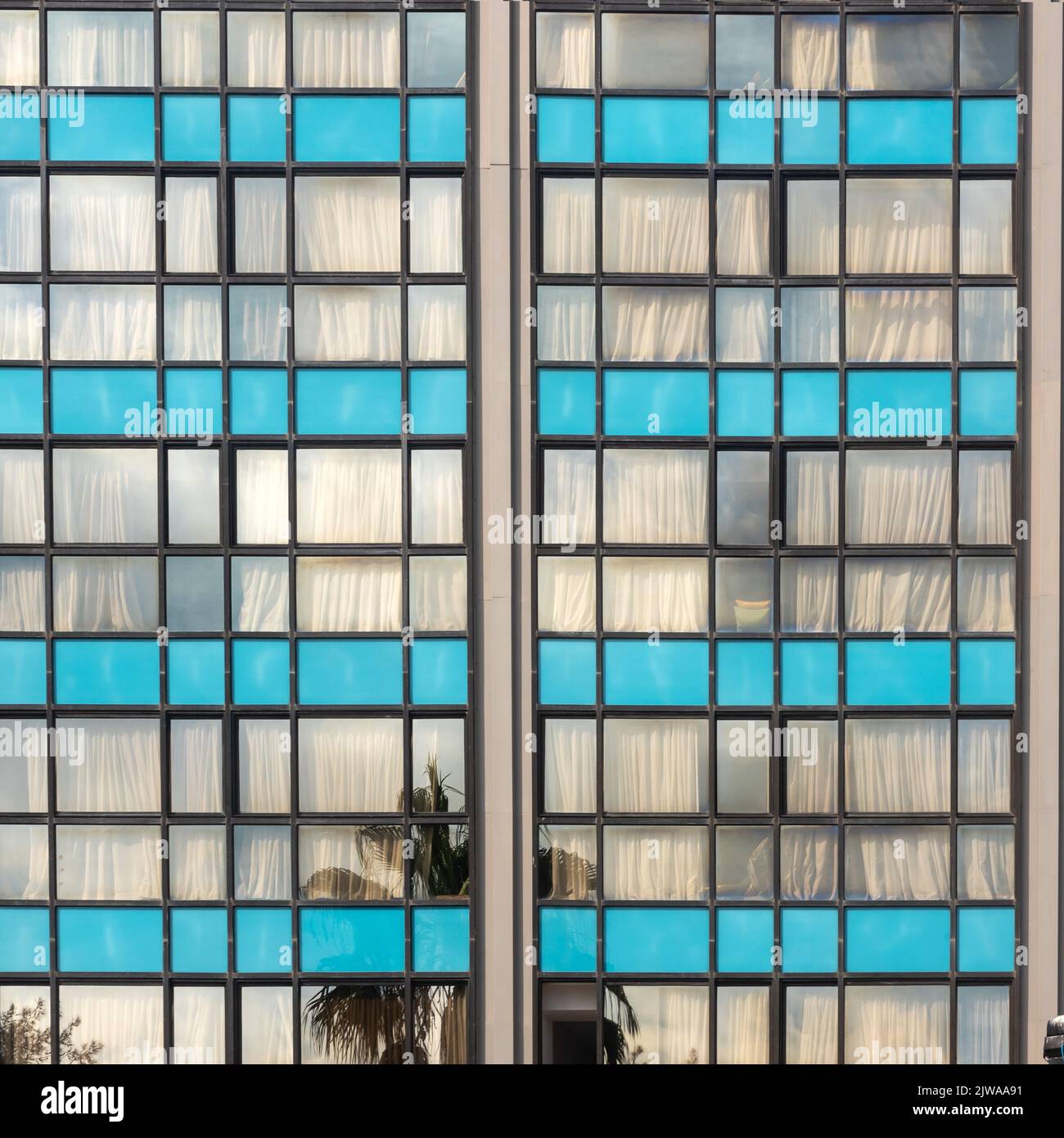Old soviet constructivist industrial building exterior facade with large windows, blue glass bricks Stock Photo