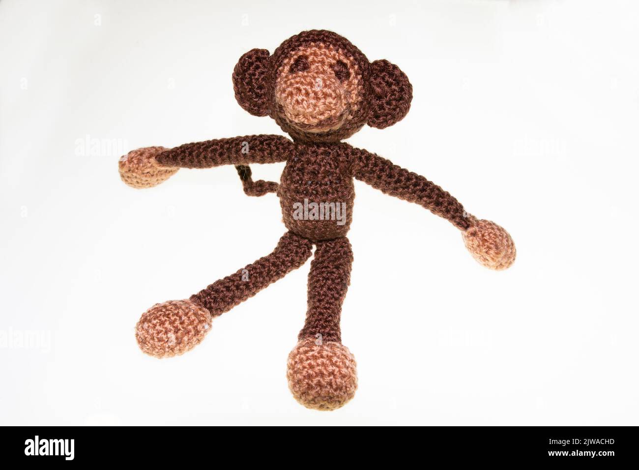 Gehäkelter kleiner Spielzeug Kuschel Affe mit Watte gefüllt Stock Photo