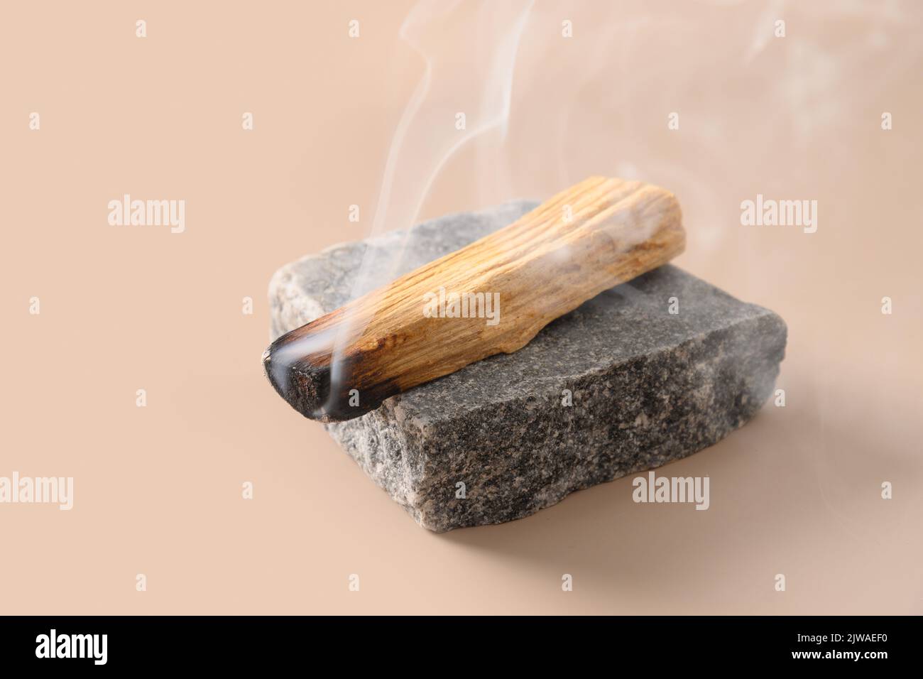 Palo Santo wood known as oily aromatic holy wood sticks smouldering on  plate in home living room cleansing negative energy concept. Bohemian style  Stock Photo - Alamy