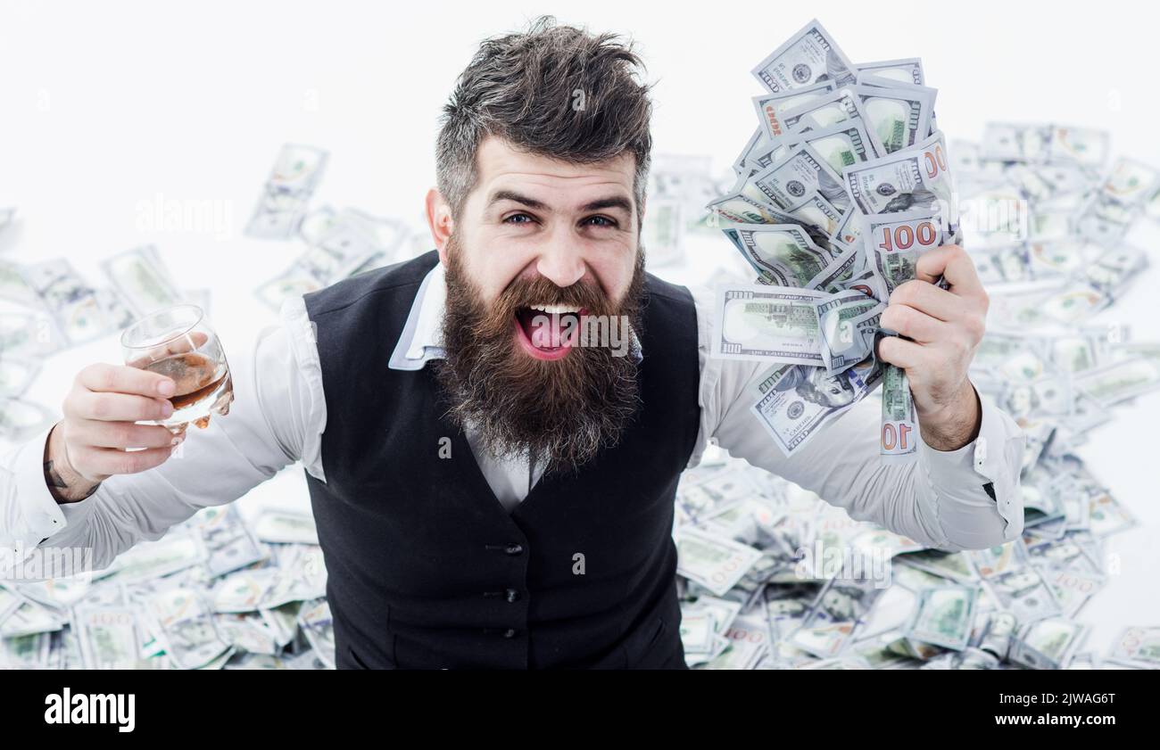Successful businessman with banknotes drinking whiskey. Excited man with money. Business success. Stock Photo