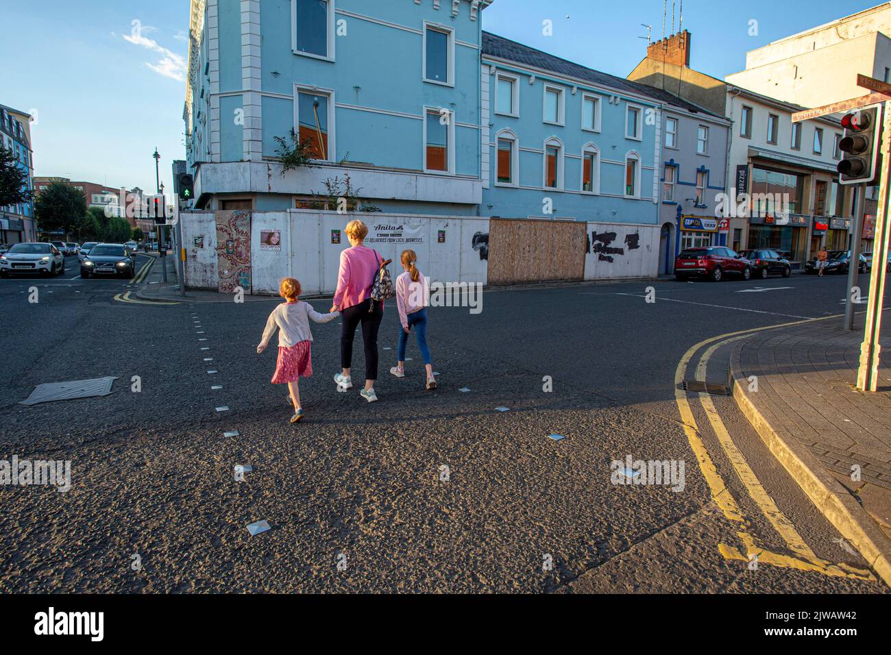 Londonderry, UK, August 2022. Mother with her daughters crossing street in Derry city Stock Photo