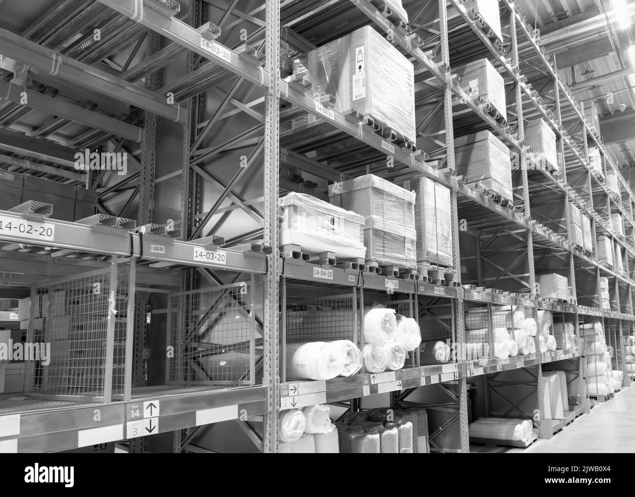 Black and white photo of the interior aisle of a warehouse with goods and boxes Stock Photo