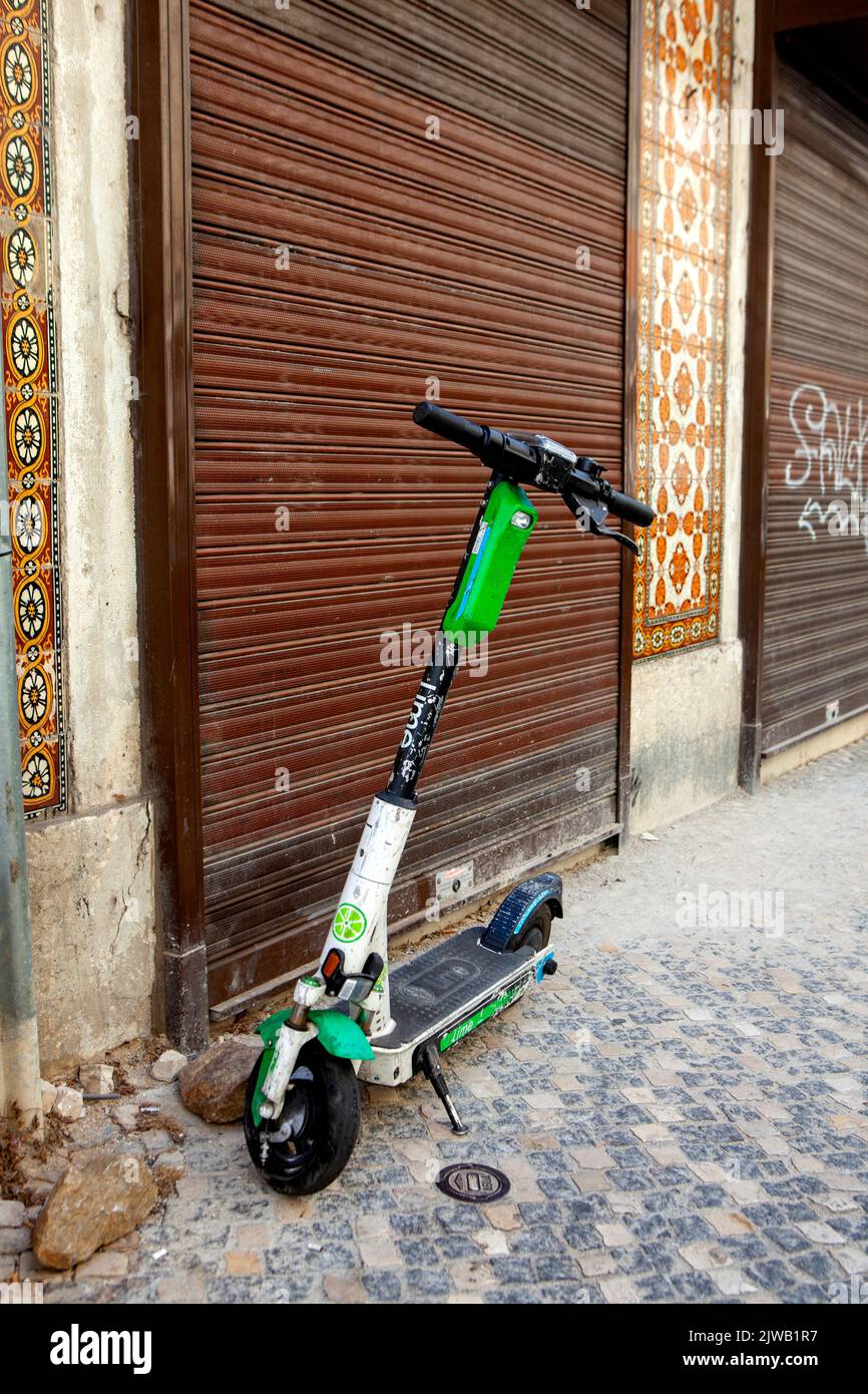 Old battered electric scooter parked in Lisbon Portugal Stock Photo