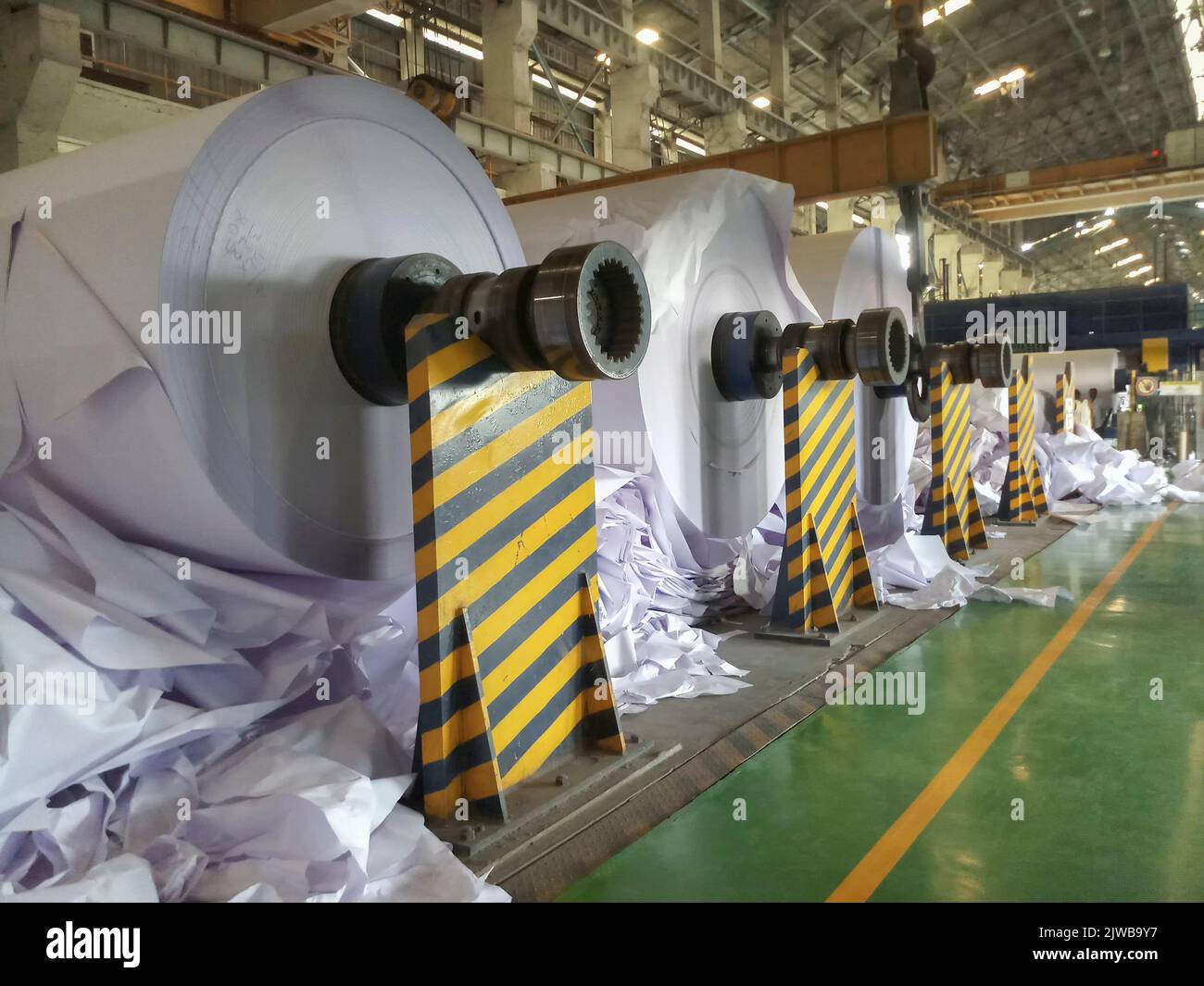 Kolkata, West Bengal, India - 16th May 2019 : White Paper Reels are being manufactured in a big paper manufacturing plant. Indian paper industry. Stock Photo