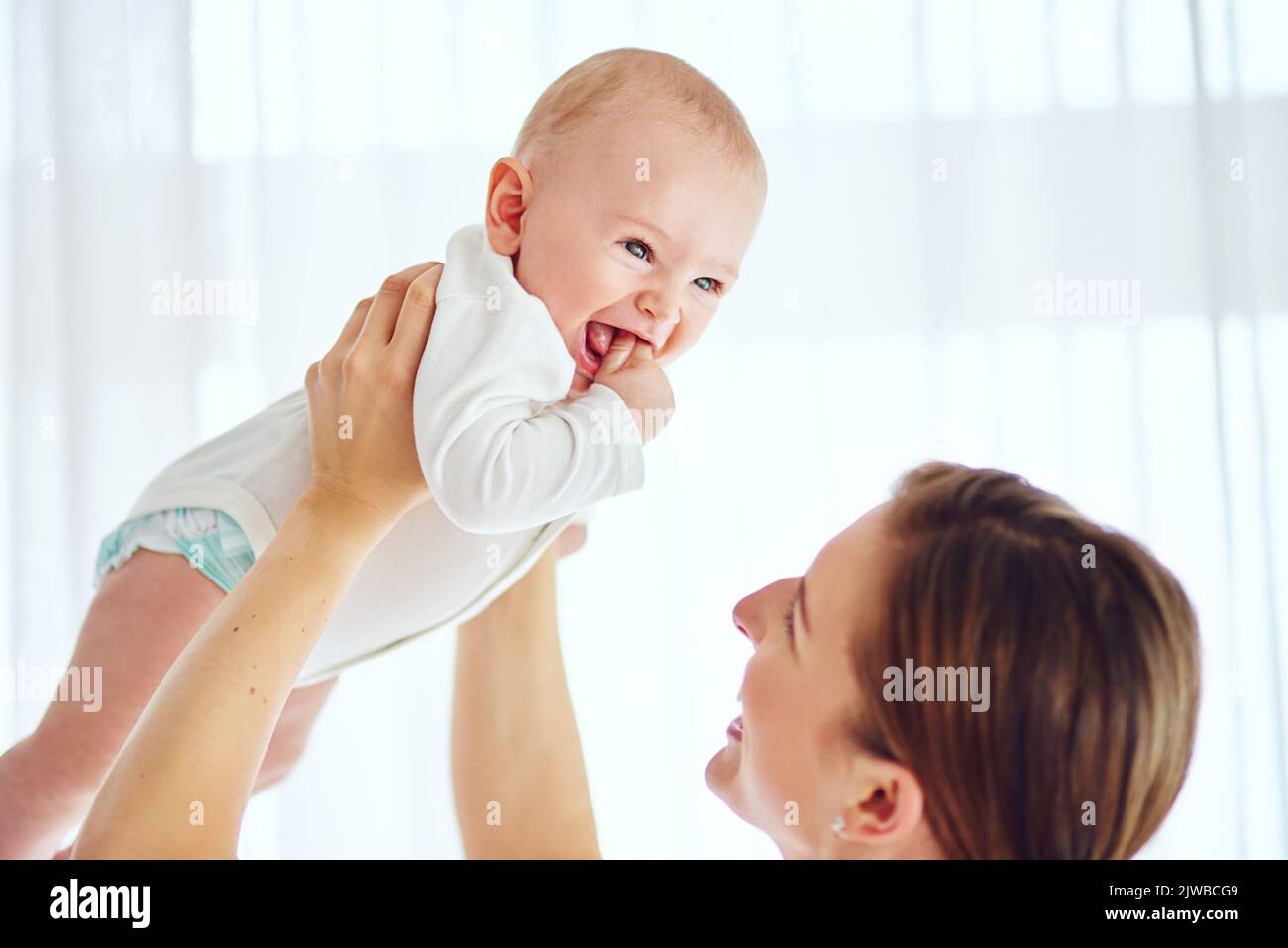 Raising him with love. a loving mother carrying her baby boy at home. Stock Photo