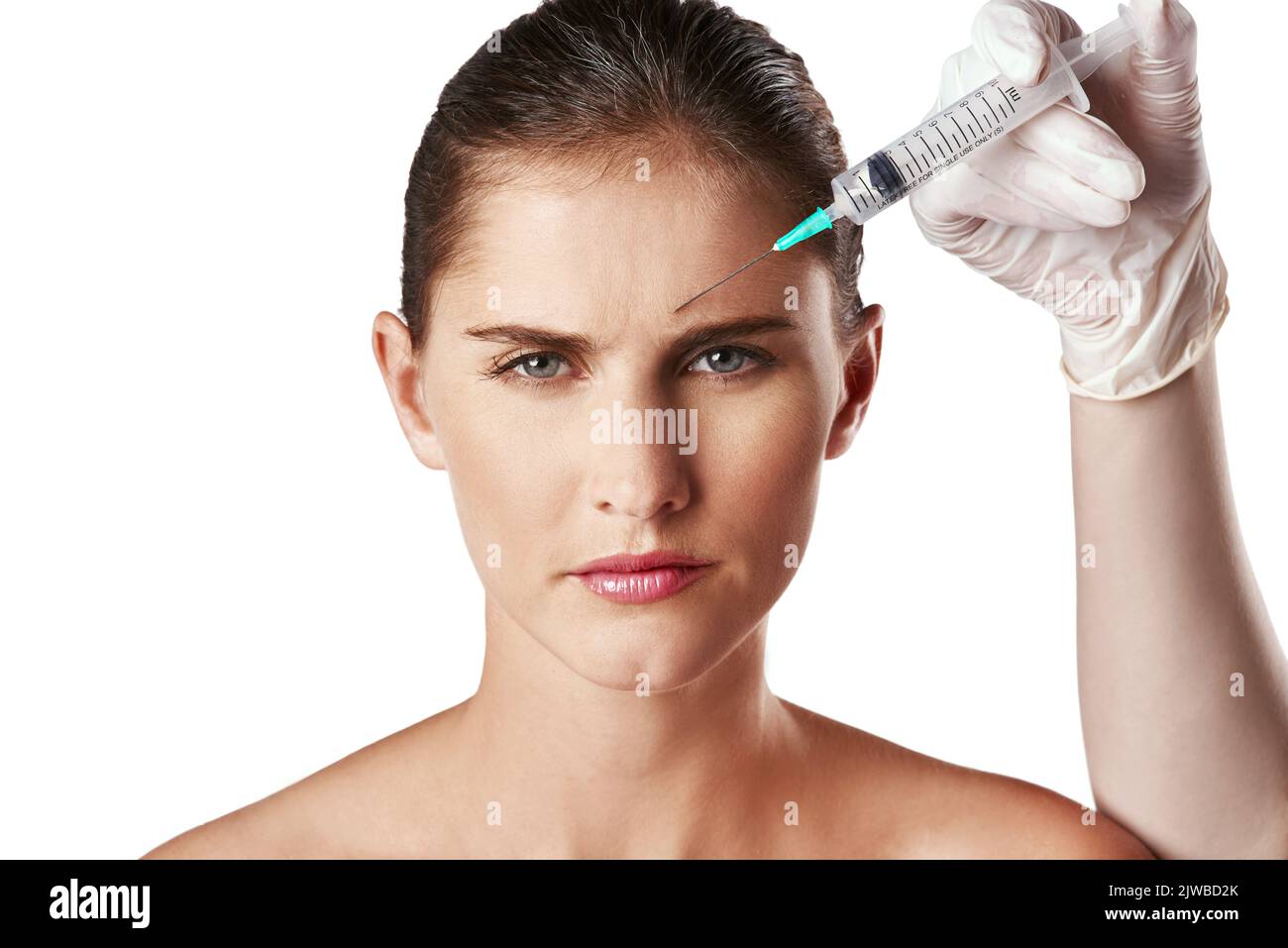 She wont let age win without a fight. Studio shot of an attractive young woman getting an injection for cosmetic purposes. Stock Photo