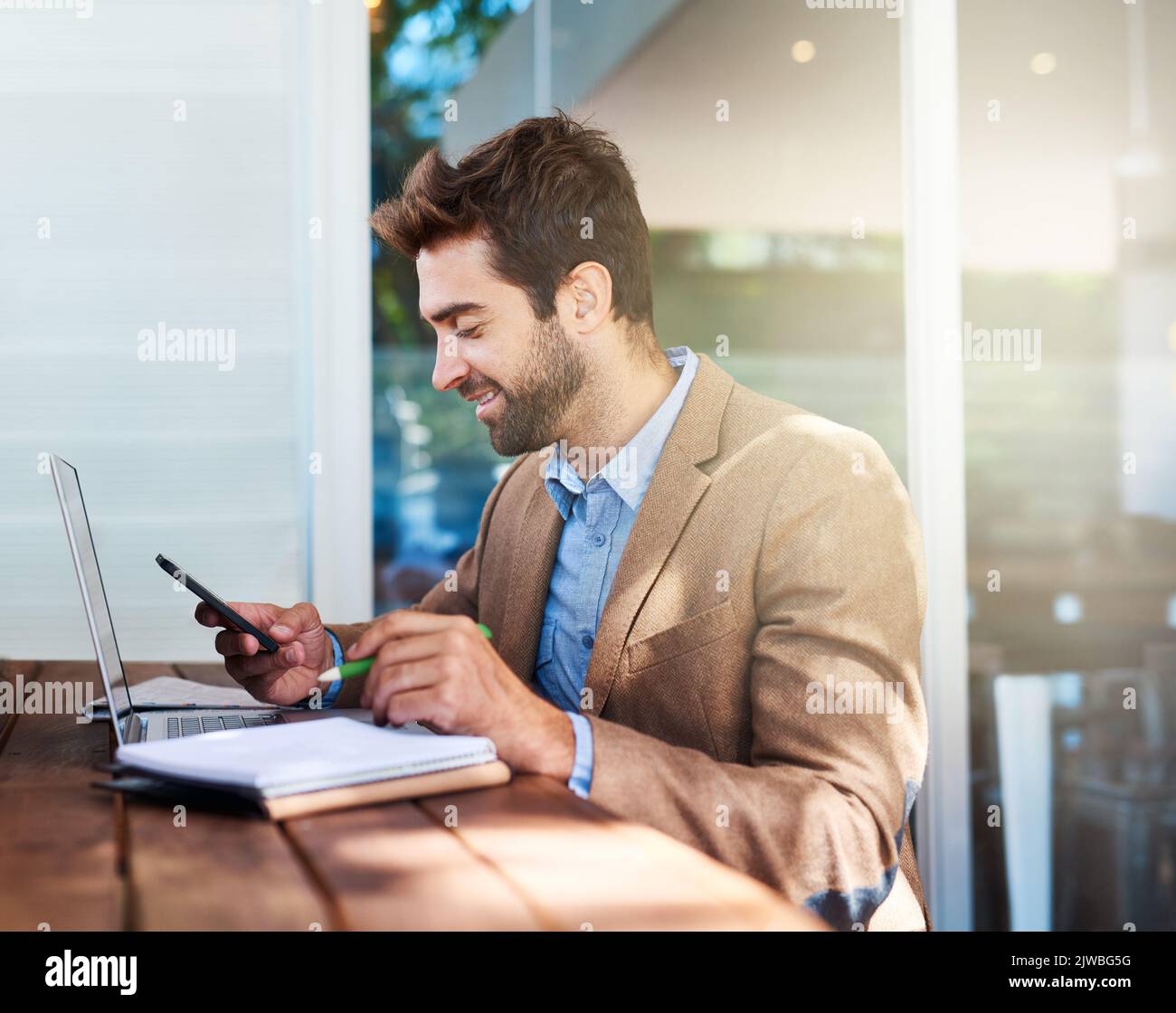 Thats what I like to see on my phone. a young entrepreneur using a phone in a cafe. Stock Photo