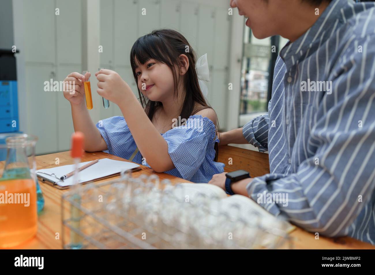 Kid and teacher doing science experiments. back to school concept Stock