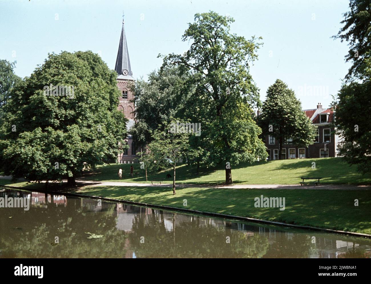 Face over the Stadsbuitengracht on the park on Pelmolenweg in Utrecht with the tower of the Geertekerk in the background. Stock Photo