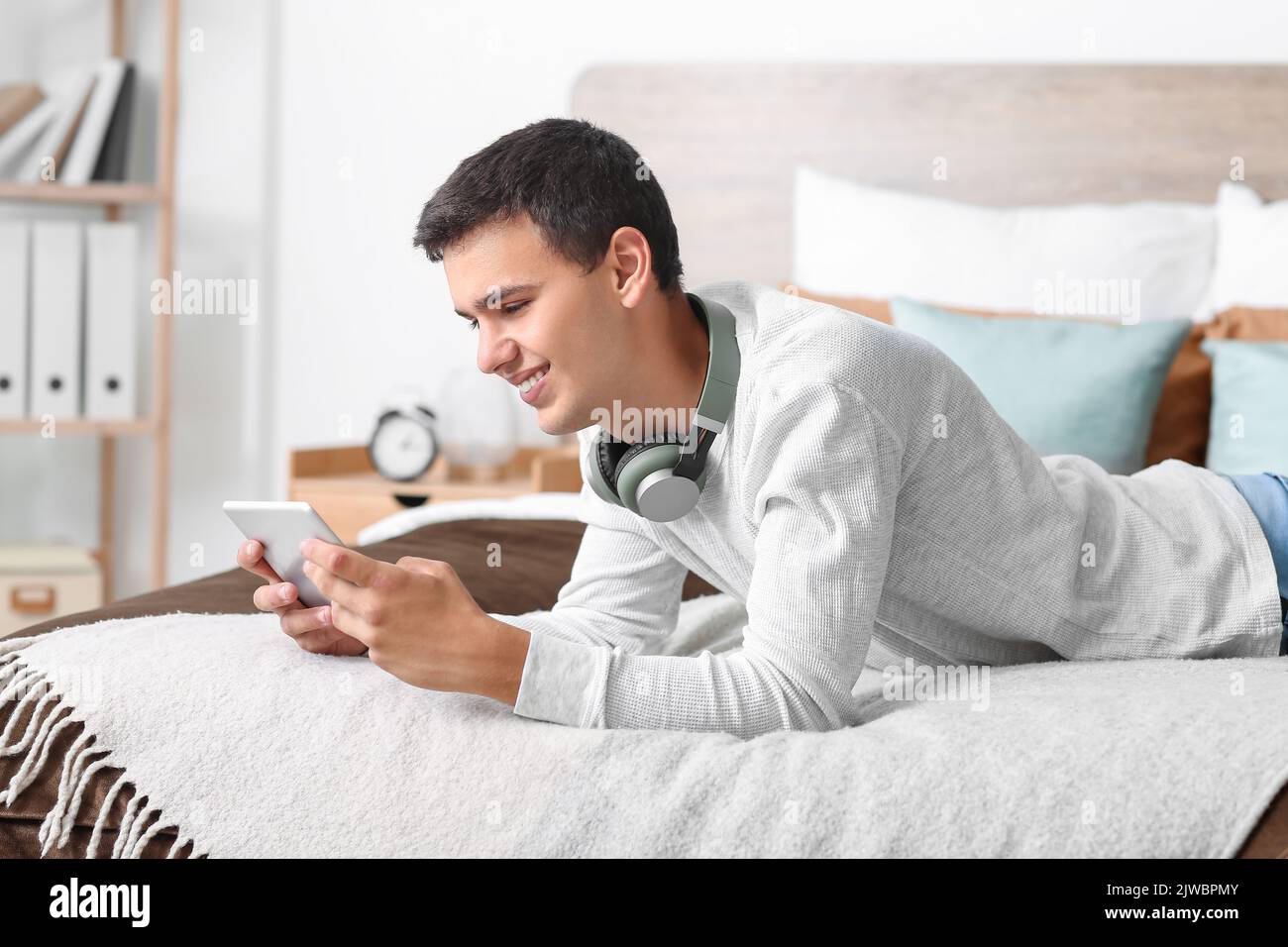 Teenage boy using tablet computer in bedroom Stock Photo - Alamy