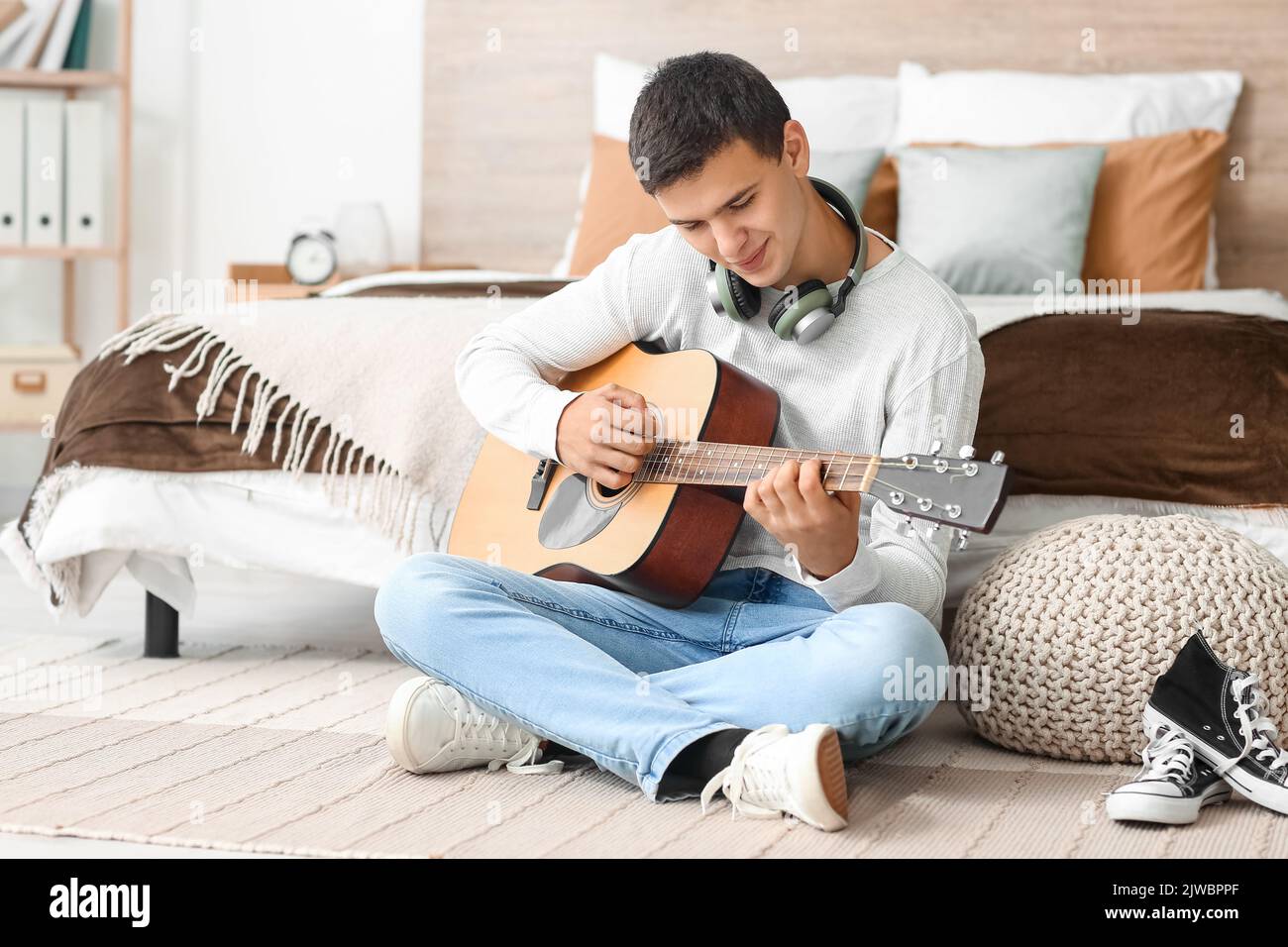 Teenage boy playing guitar in bedroom Stock Photo Alamy