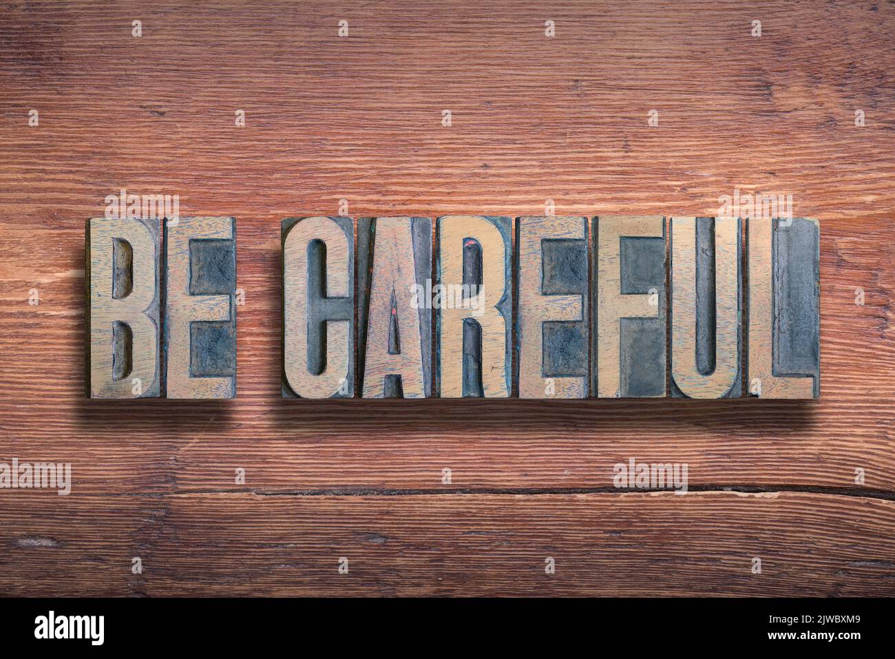 be careful phrase combined on vintage varnished wooden surface Stock Photo