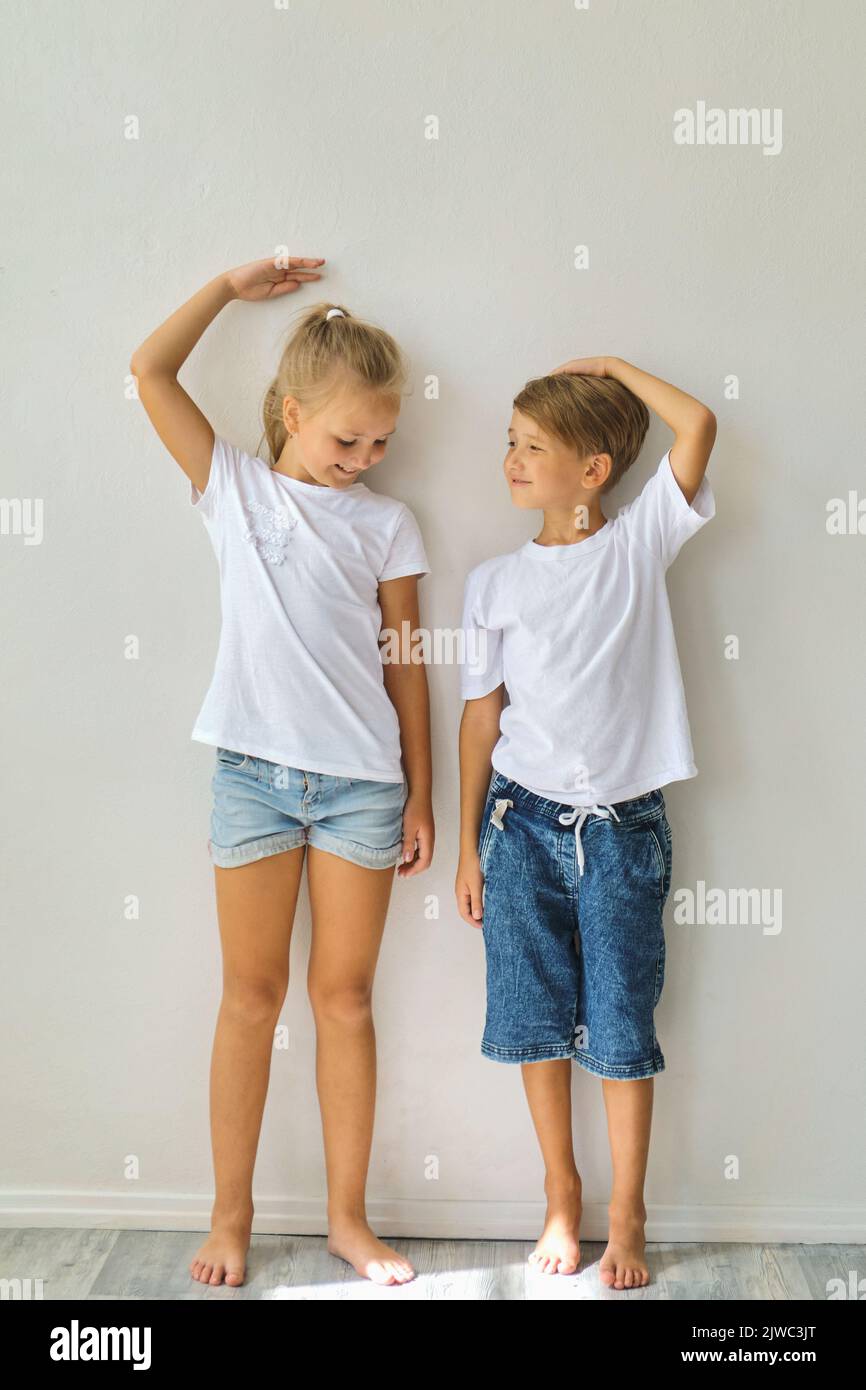 Cool kids, little boy and girl measure their height a Stock Photo Alamy