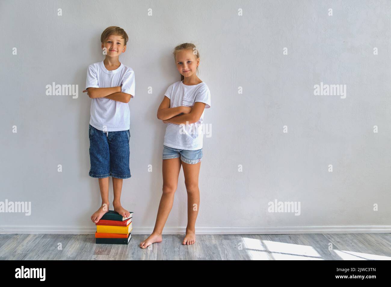 Cool kids, little boy and girl measure their height a Stock Photo