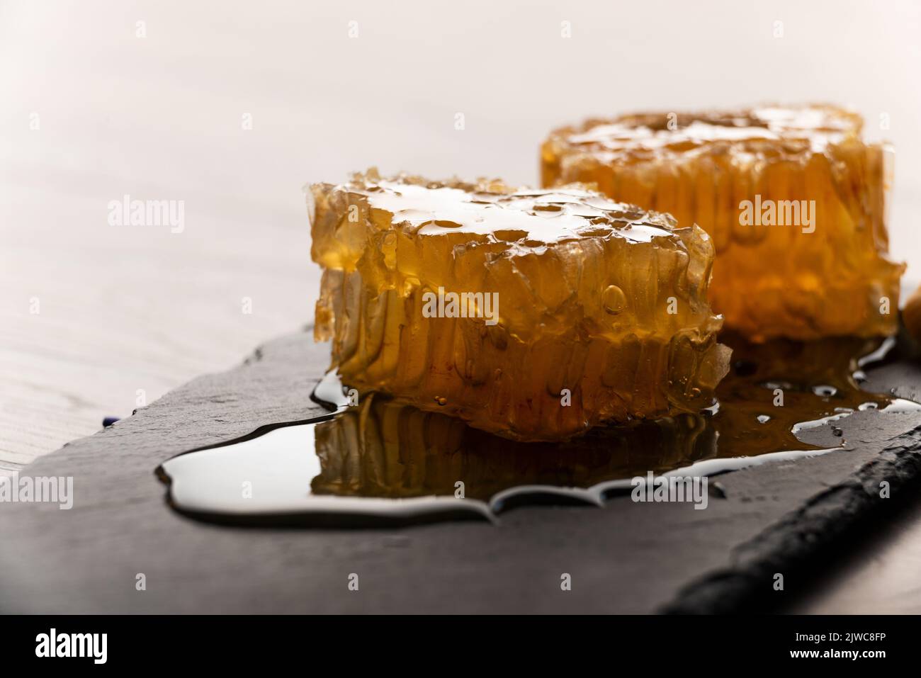 Honeycomb on slate tray on kitchen table macro view Stock Photo