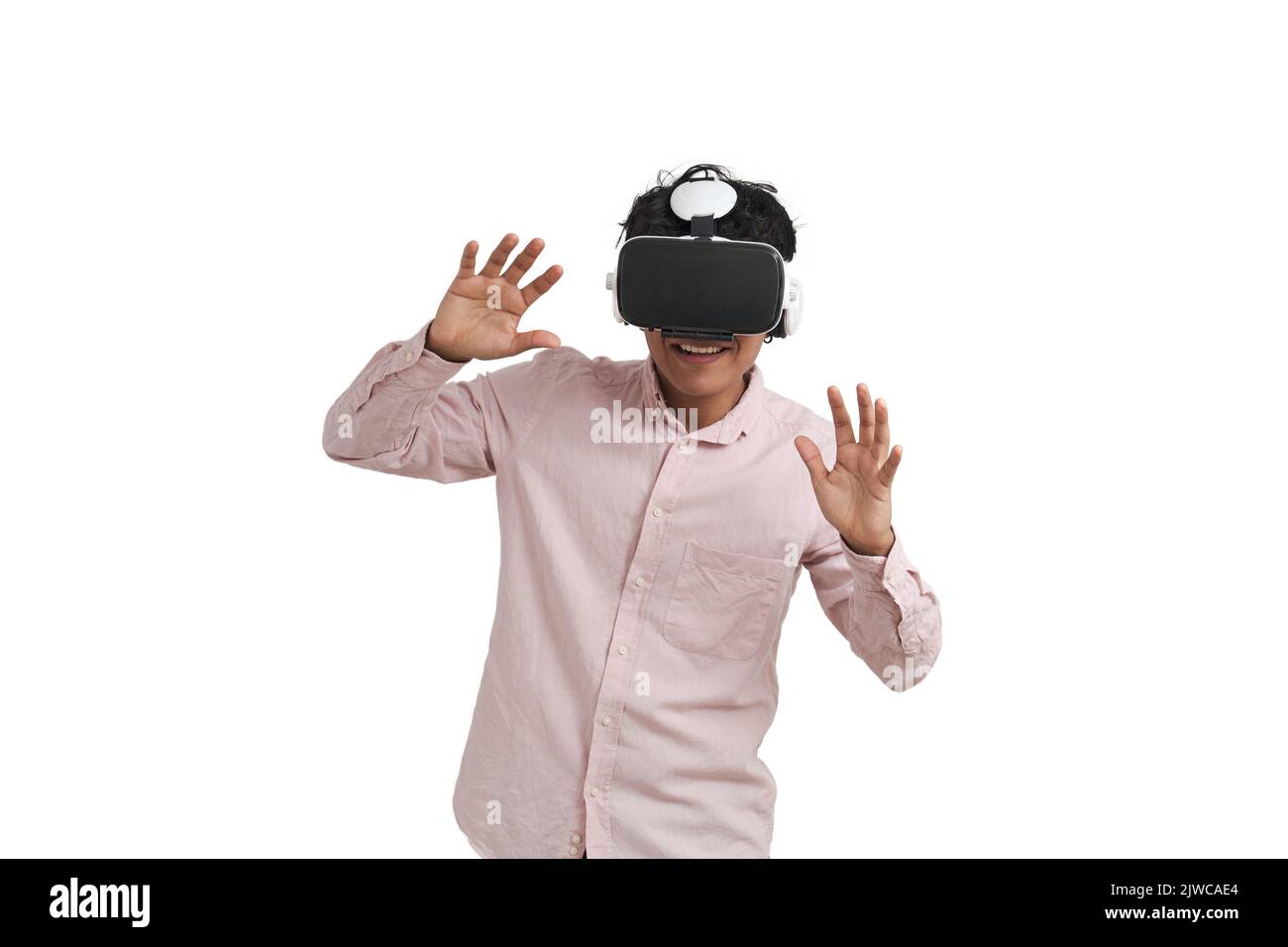 Young peruvian man laughing using virtual reality headset, isolated. Stock Photo