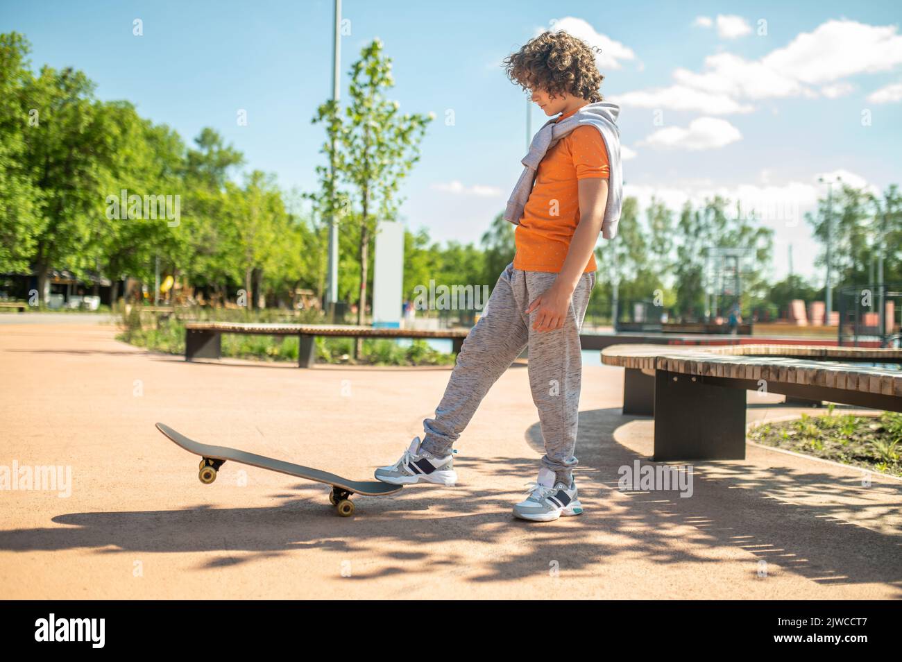 Adolescent practicing a skateboarding trick in the park Stock Photo