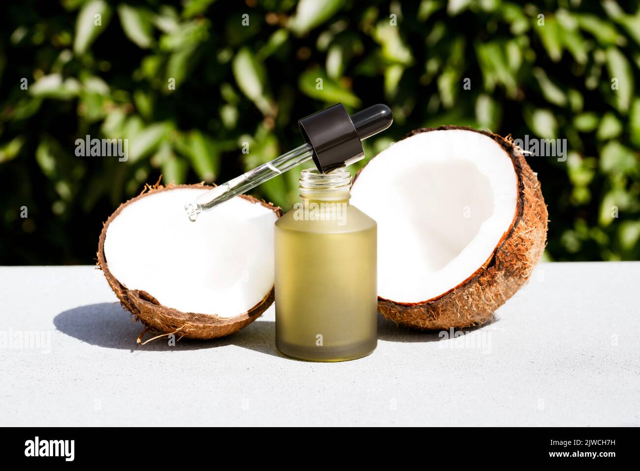 Mockup image of green glass dropper bottle with coconut cosmetic oil ...