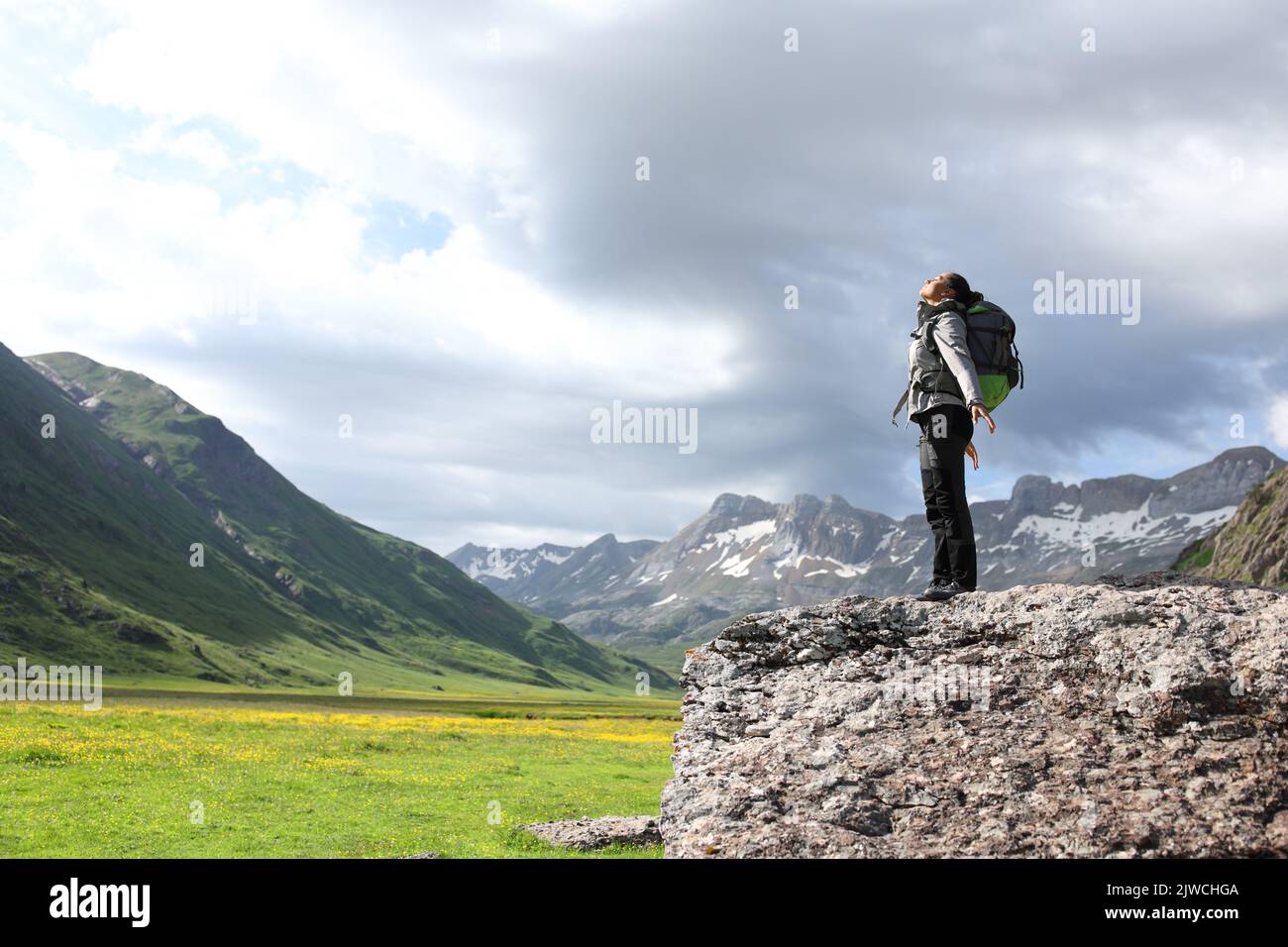 Full body portrait of a trekker breathing fresh air on the top of a rock Stock Photo