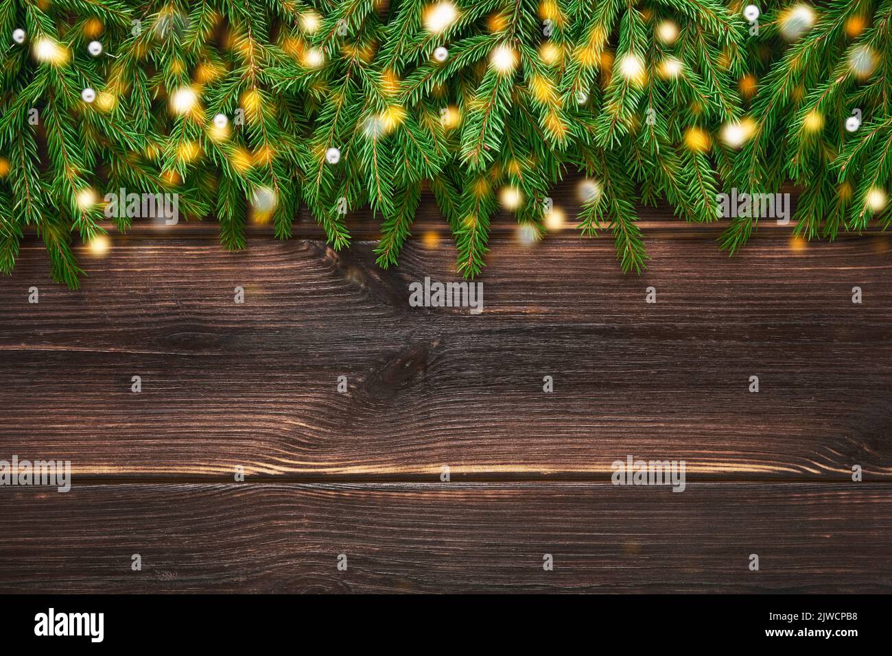 Christmas background. Christmas decoration, fir tree branches on a dark wooden background. Top view, copy space for text. Stock Photo