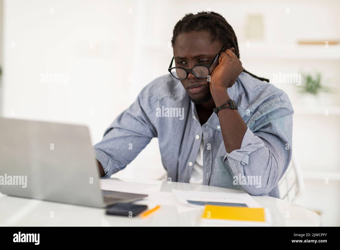 Lack Of Inspiration. Bored Black Male Freelancer Looking At Laptop Screen Stock Photo