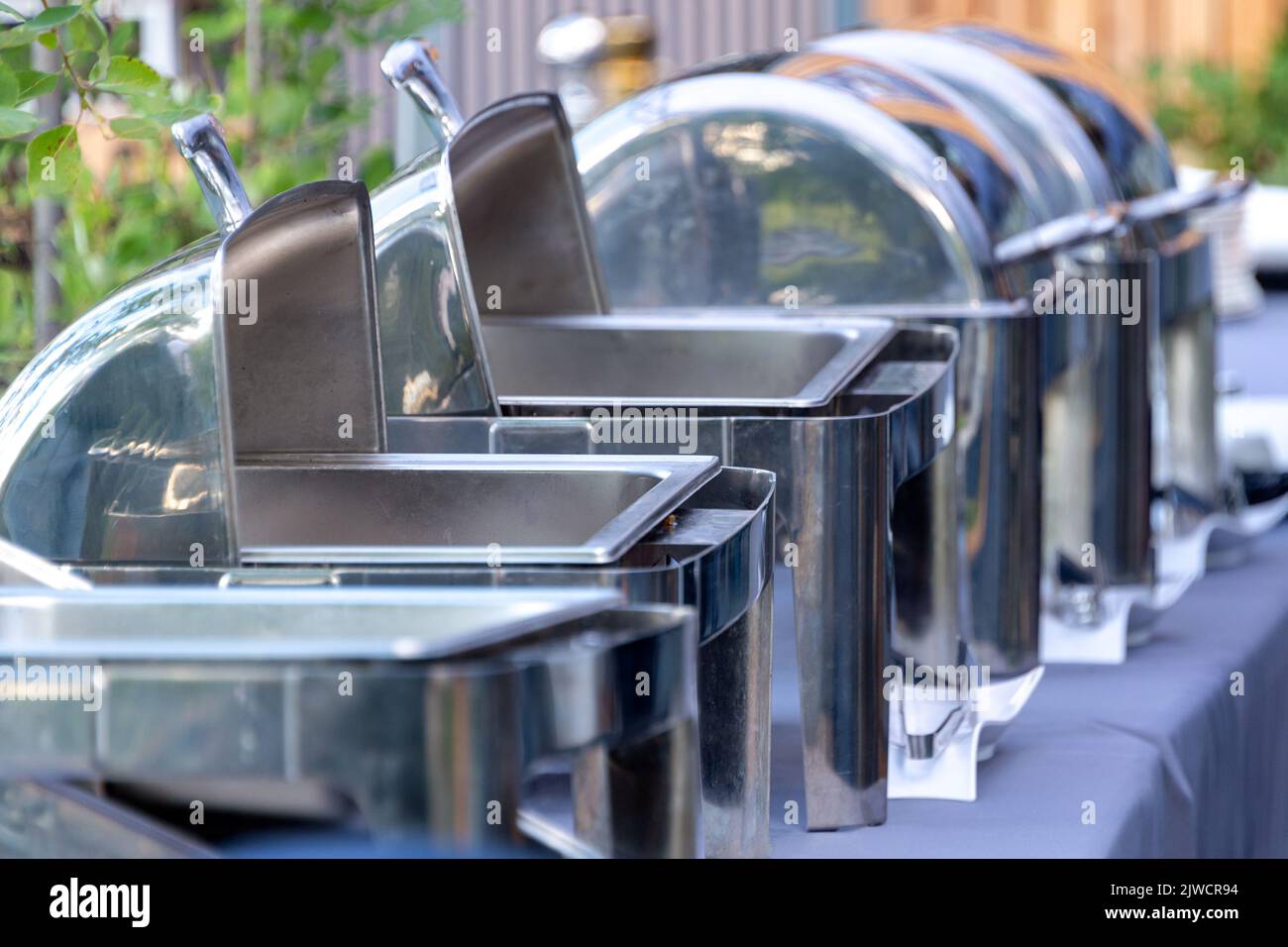 Buffet heated trays standing in line ready for service. Outdoors buffet