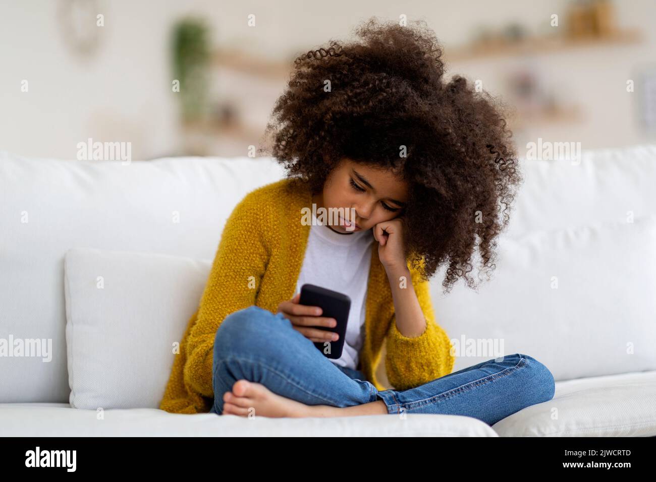 Bored african american preteen girl using cell phone Stock Photo