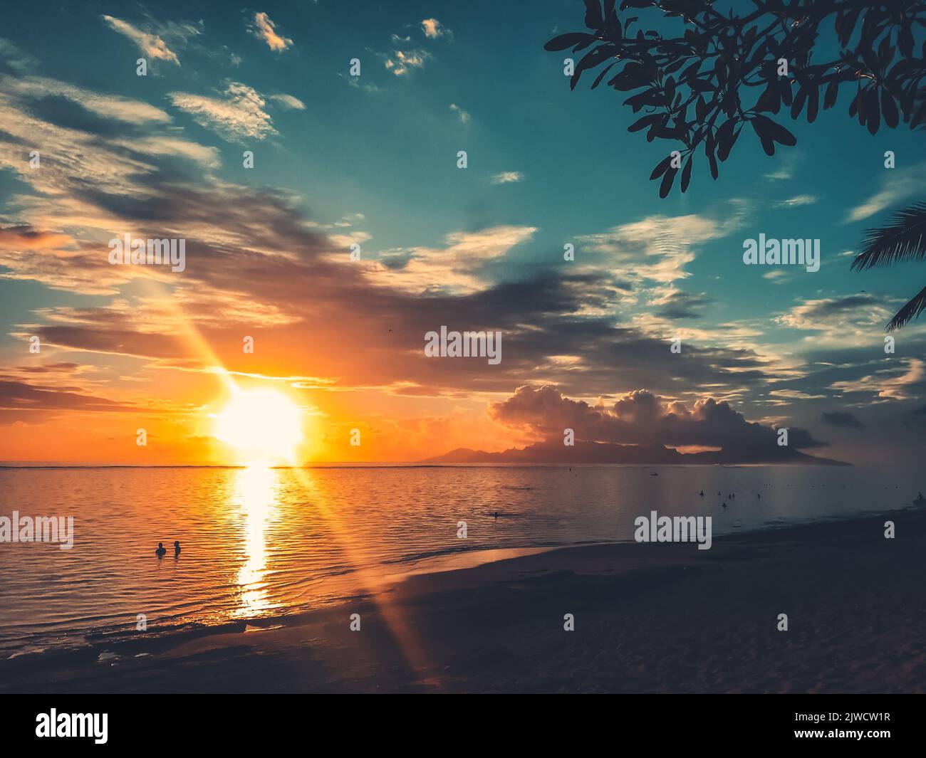 Bright orange sun sunset over sea coast. Sandy beach and cloudy sky