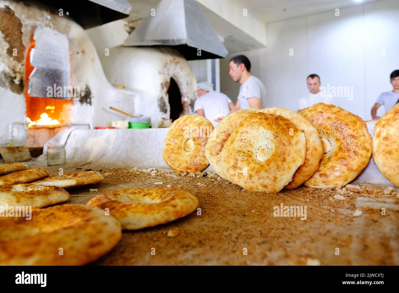 Tashkent Uzbekistan - bakers making fresh round local bread at a bakery in Chorsu Bazaar market in August 2022 Stock Photo